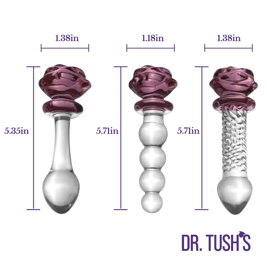 Three glass butt plugs and glass dildo with purple rose top  showing dimensions and clear design on a white background, branded 'Dr. Tush'.